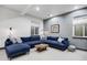 Basement living room with cozy blue sectional couch, lots of natural light, and comfortable seating at 1291 S Gaylord St, Denver, CO 80210