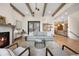 Open concept living room with fireplace, hardwood floors, and exposed wooden beams at 1291 S Gaylord St, Denver, CO 80210