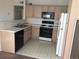 Traditional kitchen features white appliances, light wood cabinets and a black gas range at 9913 E Carolina Cir # 203, Denver, CO 80247