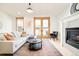 Inviting living room features a fireplace, light gray sofa, hardwood floors, and access to a balcony through wooden doors at 449 N Pearl St, Denver, CO 80203