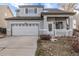 Attractive home featuring gray stucco exterior, a covered porch, and a spacious driveway leading to a two-car garage at 3869 S Himalaya Way, Aurora, CO 80013