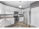 Efficient kitchen with white cabinets, stainless steel appliances, and durable tile flooring at 3869 S Himalaya Way, Aurora, CO 80013