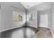 Bright living room featuring high ceilings, large windows, dark wood floors, and neutral gray walls at 3869 S Himalaya Way, Aurora, CO 80013