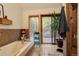 Cozy bathroom featuring a tub, sliding door leading to a deck, and stylish brown tiles at 2720 S Spring Gulch Rd, Idaho Springs, CO 80452