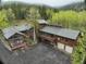An exterior elevation showing a multi-story home with a large driveway and beautiful wooded surroundings at 2720 S Spring Gulch Rd, Idaho Springs, CO 80452
