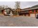 Stunning exterior showcasing a multi-level home with a three-car garage and expansive gravel driveway at 2720 S Spring Gulch Rd, Idaho Springs, CO 80452