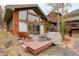 Charming outdoor deck area with seating, barrel table and steps to the house at 2720 S Spring Gulch Rd, Idaho Springs, CO 80452