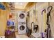 Functional laundry room equipped with washer, dryer, shelving, and various cleaning supplies for efficient home maintenance at 2720 S Spring Gulch Rd, Idaho Springs, CO 80452