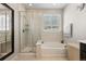 Bright bathroom with glass shower, soaking tub, and neutral tile at 398 Midden Pl, Castle Rock, CO 80104