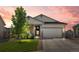 Charming home featuring a manicured lawn and stone accents, set against a beautiful sunset sky at 398 Midden Pl, Castle Rock, CO 80104
