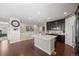 Open kitchen with a center island, dark cabinets, and wood floors connects to the living area at 398 Midden Pl, Castle Rock, CO 80104
