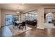 Open dining room with wooden table, rug and modern light fixture, adjacent to the living room at 4965 Malaya St, Denver, CO 80249