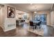 Open-concept dining room features dark wood floors, modern light fixture, and sliding glass door to the patio at 4965 Malaya St, Denver, CO 80249