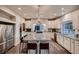 Modern kitchen featuring granite counters, stainless steel appliances, an island with bar seating, and ample cabinet space at 4965 Malaya St, Denver, CO 80249