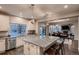 Open kitchen boasts a large island with seating, sleek appliances, granite counters, and seamless flow to living areas at 4965 Malaya St, Denver, CO 80249