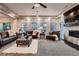 Comfortable living room featuring plush seating, a cozy fireplace with wood trim, large windows and a ceiling fan at 4965 Malaya St, Denver, CO 80249