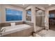 Modern bathroom featuring bathtub, shower, and window for natural light with a view to the outdoors at 4965 Malaya St, Denver, CO 80249