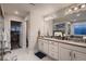 Bright bathroom with double vanity, tub, walk-in shower, and entrance to the large walk-in closet at 4965 Malaya St, Denver, CO 80249