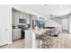 Modern kitchen featuring grey cabinets, stainless steel appliances, and island with bar stool seating at 23576 E 5Th Pl, Aurora, CO 80018