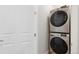 Convenient laundry area featuring stacked washer and dryer, optimizing space in the home at 23576 E 5Th Pl, Aurora, CO 80018