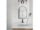 Modern bathroom with a white vanity, black fixtures, and an arched mirror at 461 S Lowell Blvd, Denver, CO 80219