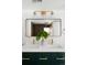 Modern bathroom vanity with double sinks, white countertop, green cabinets and an illuminated mirror at 461 S Lowell Blvd, Denver, CO 80219