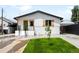 Charming single-Gathering home featuring fresh exterior paint, a green front door, and a small tree in the front yard at 461 S Lowell Blvd, Denver, CO 80219