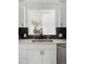 Bright kitchen featuring stainless steel appliances, white cabinets, dark tile backsplash and decorative open view at 461 S Lowell Blvd, Denver, CO 80219