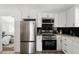 Contemporary kitchen showcasing stainless steel appliances, black backsplash, and white cabinets for a sleek design at 461 S Lowell Blvd, Denver, CO 80219
