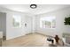 Sun-filled living room with modern lighting, wood-look flooring and multiple windows at 461 S Lowell Blvd, Denver, CO 80219