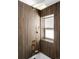 Stunning shower featuring a wood-paneled wall and a brass rainfall shower head and handheld sprayer at 461 S Lowell Blvd, Denver, CO 80219