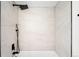 Bright shower featuring white tile walls and matte black rainfall shower head and handheld sprayer at 461 S Lowell Blvd, Denver, CO 80219
