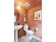 Chic half-bathroom with decorative art, pedestal sink, and a rustic, warm color scheme at 8057 Monte Vista Cir, Littleton, CO 80125