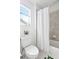 Clean and well-lit bathroom with tile surround tub/shower, toilet, and window at 8057 Monte Vista Cir, Littleton, CO 80125