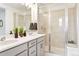 Bright bathroom with double vanity, glass shower, modern fixtures, and ample counter space at 8057 Monte Vista Cir, Littleton, CO 80125