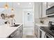 Bright modern kitchen featuring white countertops, stainless steel appliances, and stylish pendant lighting at 8057 Monte Vista Cir, Littleton, CO 80125
