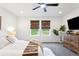 Comfortable bedroom with ceiling fan, neutral colors, and natural light streaming through bamboo shades at 8057 Monte Vista Cir, Littleton, CO 80125