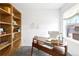 Bright office space featuring a modern desk, shelving unit, and a comfortable white chair at 8057 Monte Vista Cir, Littleton, CO 80125
