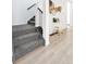 Carpeted staircase with dark railings alongside light hardwood flooring and decorative baskets on the wall at 8057 Monte Vista Cir, Littleton, CO 80125