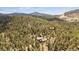 Breathtaking aerial view of a secluded home nestled among lush trees and mountains at 20496 Stonewood Trl, Morrison, CO 80465