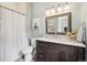 Charming bathroom featuring a wooden vanity, granite countertop, and shower-tub combination at 20496 Stonewood Trl, Morrison, CO 80465