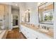 Bright bathroom with double vanity, granite countertops, and walk-in shower with a luxurious walk-in closet at 20496 Stonewood Trl, Morrison, CO 80465
