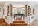 Dining room with wood floors, decorative wooden pillars, and a bay window looking out to the trees at 20496 Stonewood Trl, Morrison, CO 80465