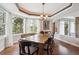 Well-lit dining room featuring a large wood table, many windows, and a decorative trey ceiling at 20496 Stonewood Trl, Morrison, CO 80465