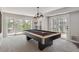 Bright game room features a pool table with modern lighting and access to the outdoor area at 20496 Stonewood Trl, Morrison, CO 80465