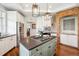 Bright kitchen featuring an island with cooktop, stainless steel appliances, and brick design at 20496 Stonewood Trl, Morrison, CO 80465