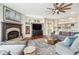 Inviting living room featuring a fireplace, hardwood floors, a large sectional sofa, and a ceiling fan at 20496 Stonewood Trl, Morrison, CO 80465