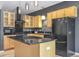 Spacious kitchen featuring black appliances, wood cabinets, and a center island at 1438 Little Raven St # 201, Denver, CO 80202