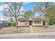 Charming home with a brick exterior, well-maintained front yard with gravel landscaping, and mature trees at 6953 Elati Way, Denver, CO 80221