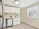 Compact kitchen with stainless steel appliances, white cabinets, stylish backsplash, and lots of natural light at 6953 Elati Way, Denver, CO 80221